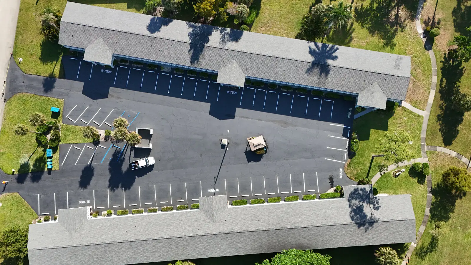 The same condo community parking lot after Florida Sealcoat and Striping completed two coat sealcoating and fresh white striping with ADA accessible stalls in Southwest Florida