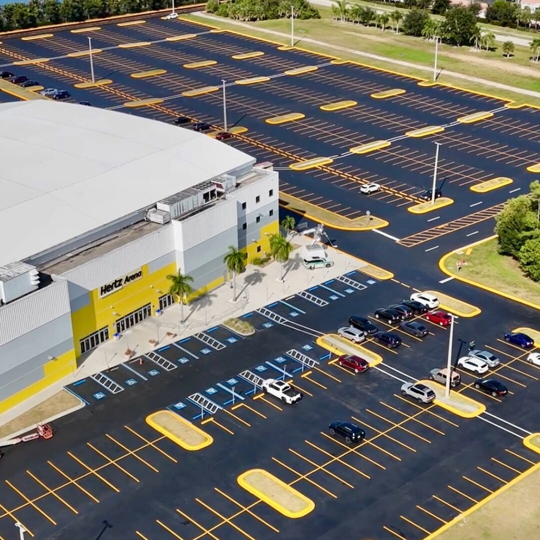 Aerial view of a large freshly striped parking lot with ADA stalls at Hertz Arena in Southwest Florida