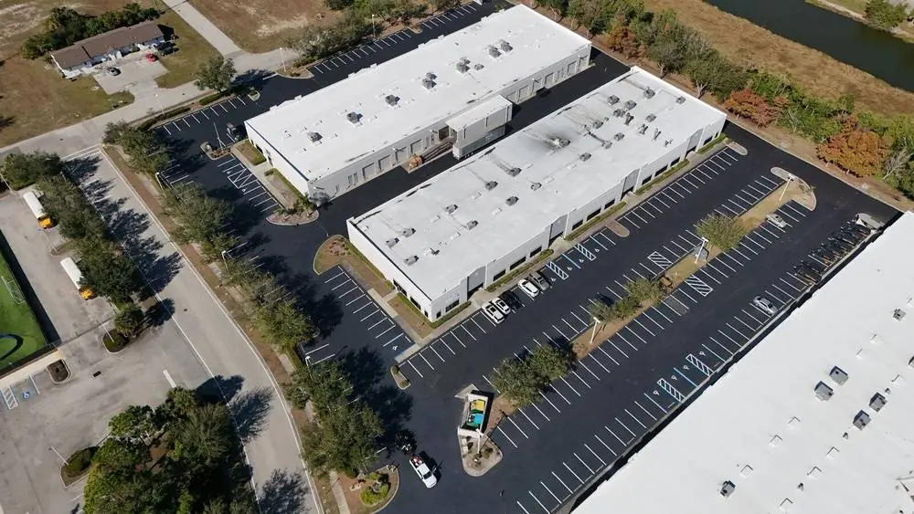 Aerial view of a freshly sealcoated and striped multi building industrial complex parking lot in Southwest Florida