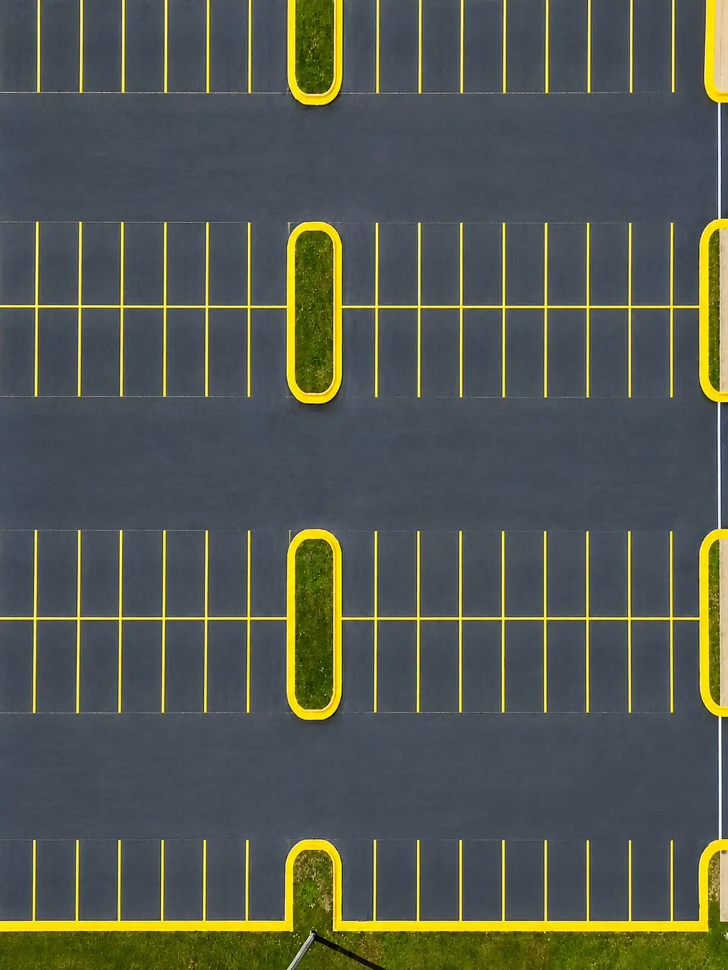 Aerial view of a freshly sealcoated parking lot with crisp yellow striping in Southwest Florida