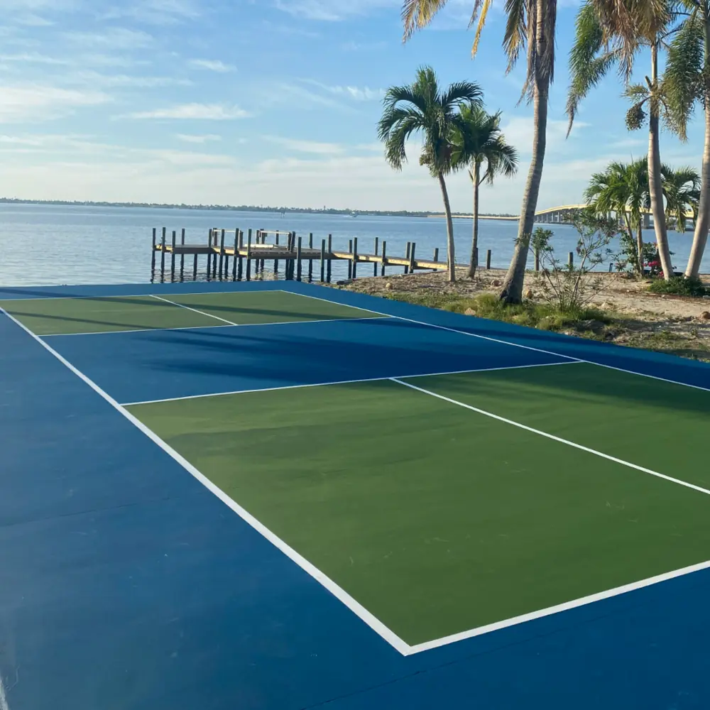Newly constructed waterfront residential pickleball court with blue and green acrylic surface in Fort Myers Florida