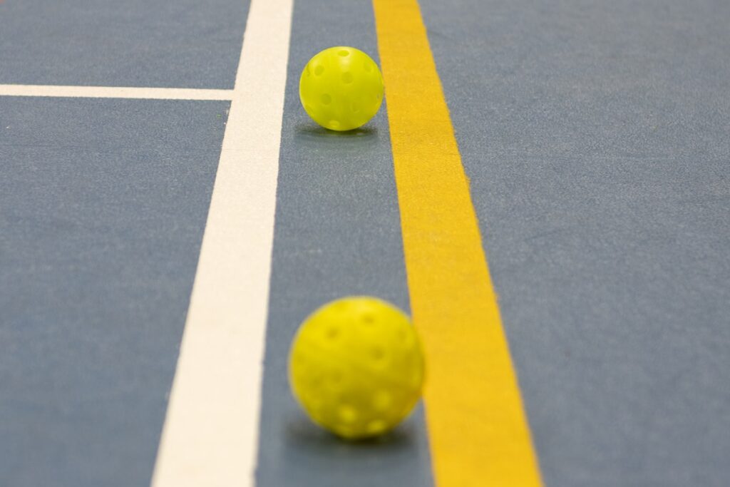 three yellow balls sitting on a tennis court